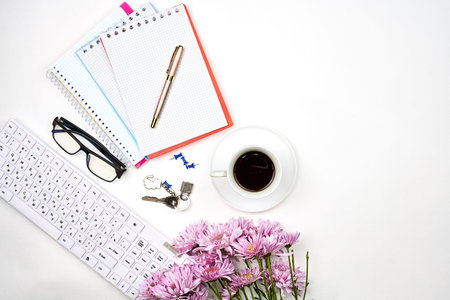 Bright workspace of a businesswoman. Bouquet of fresh spring flowers, notepads and refreshing...