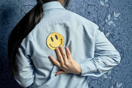 April fools day jokes. A smile sticker on the female back. 1 April fools day. Funny day. April fish. Prank. Back with stickerの写真素材