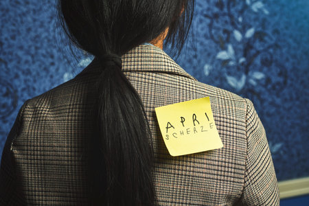 Aprilscherze. Translation from German language - April fools day. A woman with a funny sticker on...