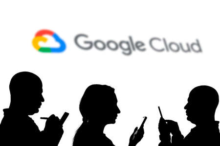 Tashkent, Uzbekistan - March 4, 2021: Silhouette of people over Popular cloud platform by Google company - Google cloud logo logotype on a large screenのeditorial素材