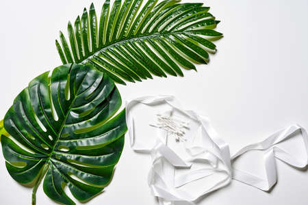 A handful of cotton swabs and leaf on white backgroundの写真素材