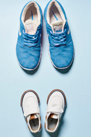 Childrens and adult pair of sneakers on isolated background