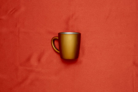 Decorative golden leaves on red textile backdrop. Bright, glamour autumnal concept with fake fall...