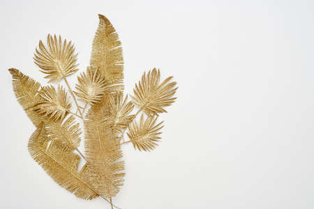 Decorative golden autumn leaves. Fake autumnal leaves on white background. Decorative fall leaves. Golden autumn, Autumn vibes conceptsの写真素材