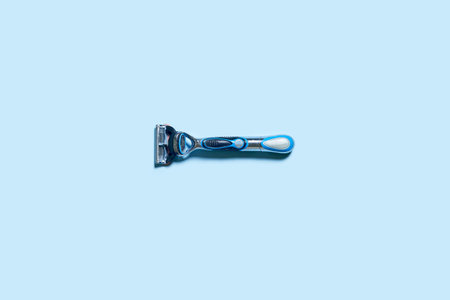 Mens shaving razor. A multiple use shaving razor on blue background. View from aboveの写真素材