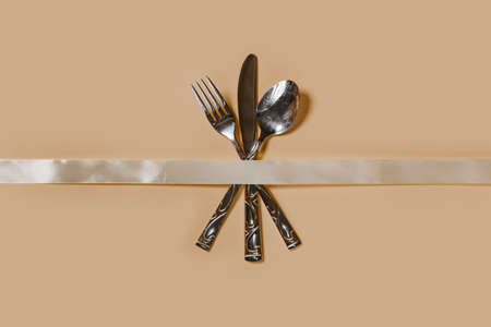 A set of cutlery - fork, spoon and knife. Top view. Pastel backgroundの写真素材