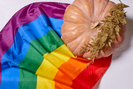 LGBTQ rainbow flag and big orange pumpkin. Halloween pumpkin with rainbow LGBT flagの写真素材