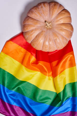 LGBTQ rainbow flag and big orange pumpkin. Halloween pumpkin with rainbow LGBT flagの写真素材