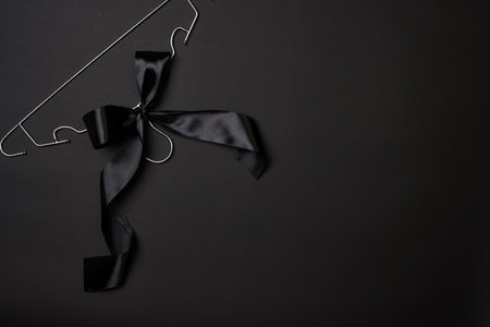 Black friday concept. Steel Cloth Hanger with black ribbon on dark backgroundの写真素材