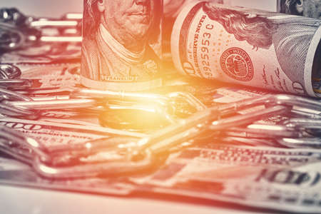 Pile of money, chain and bitcoin. Bitcoin and one hundred dollar banknotes with chain. Cryptocurrency in cyberspace as a system of payment. Crime, corruption conceptsの写真素材
