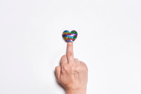love. Middle finger and heart shape balloon. Hand of person showing handgesture over white backgrounbdの写真素材