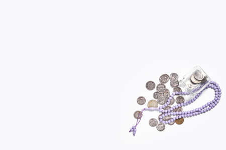 Concept of islamic finance on white background. Sharia-compliant finance - banking or financing activity. Coins and praying beads. Zakat, islamic bankingの写真素材