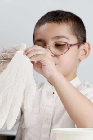Little scientist kid wearing protective glove before his chemistry experiments with liquidsの写真素材