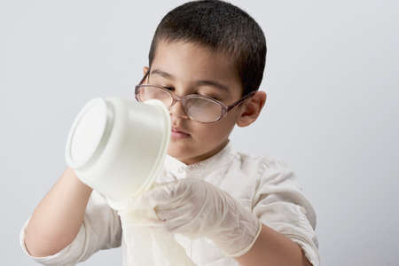 Portrait of a mixed race kid making experiments at homeの写真素材