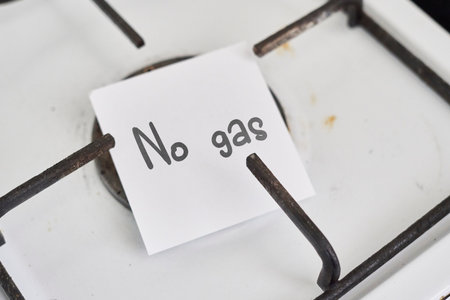 An old and grungy gas stove with no gas and piece of paper with text - No gasの写真素材