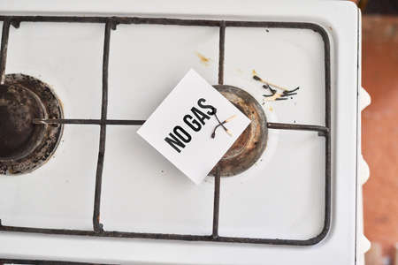 An old and grungy gas stove with no gas and piece of paper with text - No gasの写真素材