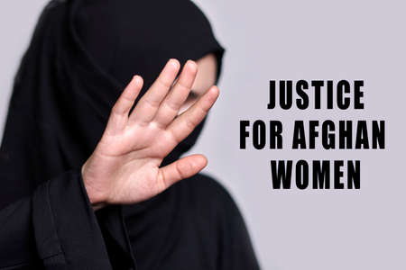 Justice for afghan women. Women rights in Afghanistan. Muslim woman in traditional black hijab clothing showing stop hand gesture. Domestic violence, discrimination of Muslim womenの写真素材
