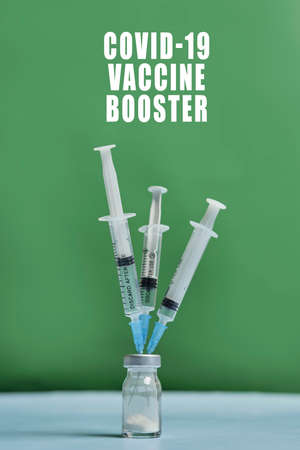 A covid-19 vaccine vial with syringes. Covid-19 vaccine booster dose. Booster shot of new coronavirus vaccine injectionの写真素材