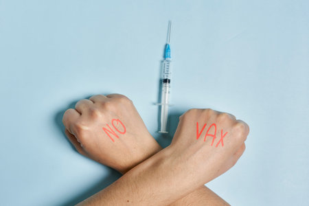 Antivaxxer crossing hands near the syringe with vaccine. A person refusing immunization against virus. skepticism conceptの写真素材