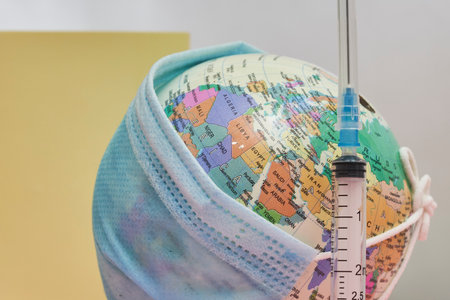 Globe in face mask and syringe. New vaccine against  variant. Symbol of global roll-out new generation of vaccine against strain of . variant vaccineの写真素材