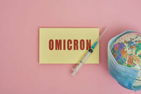 Globe in face mask and syringe. New vaccine against Omicron variant. Symbol of global roll-out new generation of vaccine against Omicron strain of cvirus. Omicron variant vaccineの写真素材