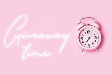 Giveaway time with alarm clock on pink background. Christmas giveawayの写真素材