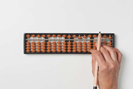 Doing mental math or mental arithmetic. Hand of person using abacus for calculating. Learning to use abacus on mental math coursesの写真素材