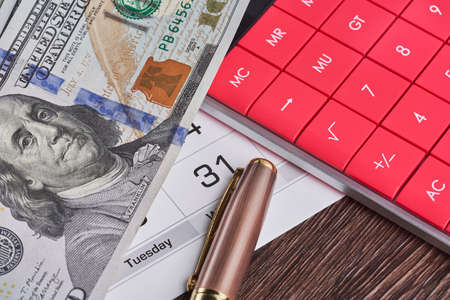 Calculator, us dollars and monthly calendar. Pay day, last day concepts. Concept of pay day, pay for utility bills, pay debts. Last day for paying loans, paying credits and billsの写真素材
