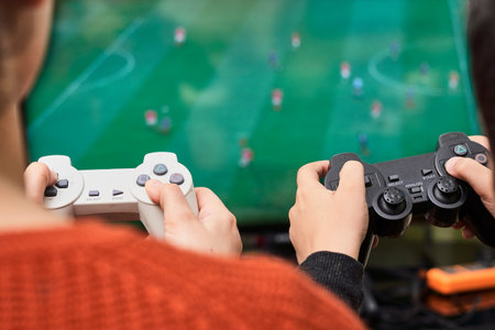 A little boy playing soccer on a gaming console. Cropped shot of a kid from behind, playing football...