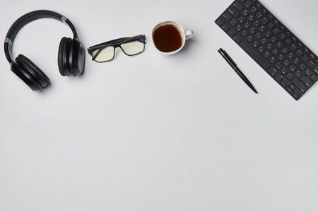 Bright office workspace. Work space with notepad, keyboard, coffee and glasses. Work space table...