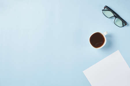 Bright office workspace. Work space with notepad, keyboard, coffee and glasses. Work space table desk. Flat lay, top view, copy spaceの写真素材