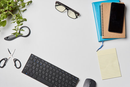 Bright office workspace. Work space with notepad, keyboard, coffee and glasses. Work space table desk. Flat lay, top view, copy spaceの写真素材