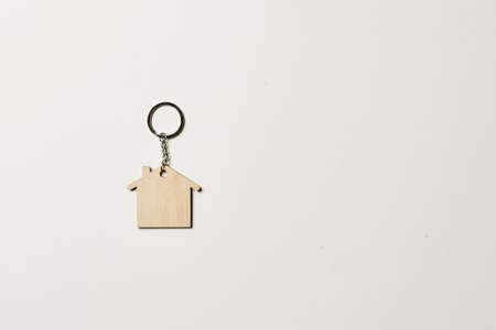 House key with trinket on white background, top view with copy space. House key on white background. Minimal flat lay style with place for text.の写真素材
