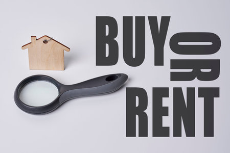 Magnifying glass with wooden house model on white background, Text buy or rent. Home inspection concept.の写真素材