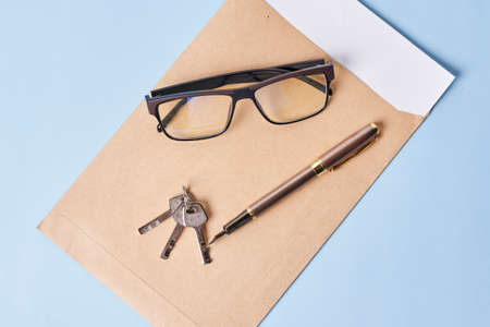 Envelope and financial documents with key on blue background. Close upの写真素材