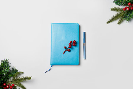 Christmas background with blue notebook, fir branches and decorations. Space for text. Top view.の写真素材