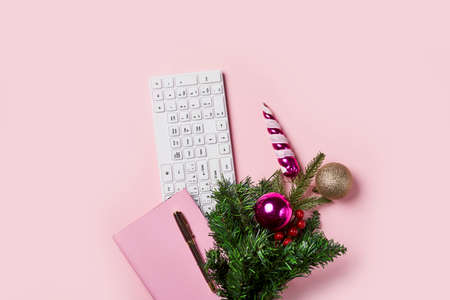 Pink notebook and christmas tree on pink backgraund. Flat lay desk with pink notebook and christmas decoration. Working, business, office, home work, winter holidays, greeting card conceptの写真素材