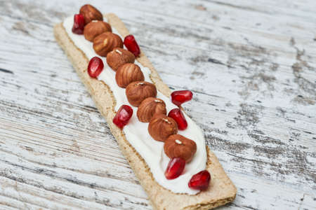 Crispbreads with cream cheese and nuts on white wooden backgraund. Top view.の写真素材
