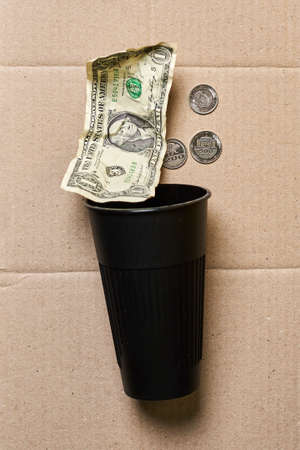 a penny and a dollar in Cup on peper background.The concept of povertyの写真素材