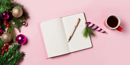 New Year background. Green fir branches with an open notebook and christmas decorations, coffee cup. Christmas workspace. Top viewの写真素材