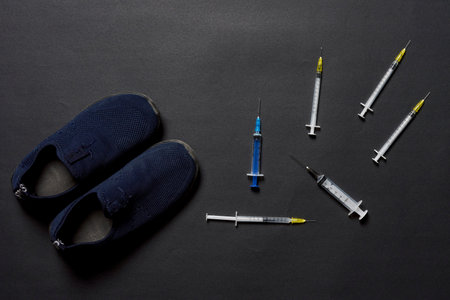 DOPING: A lot of syringes fall near a sneakers - top viewの写真素材