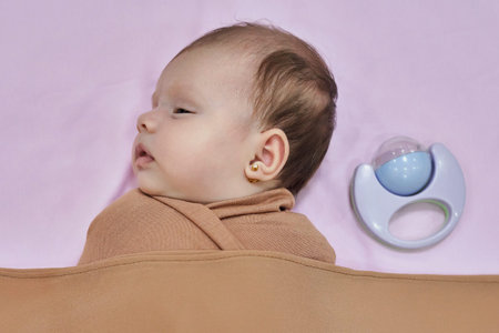 Newborn baby girl, sleeping on a blanket.