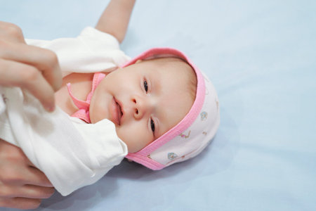 Young mother wears little baby girls dreess. Motherhood, sweet family, cute newborn baby girl....