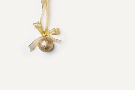 a gold christmas ball on a white background with copy space in the bottom right handout is available for purchaseの写真素材