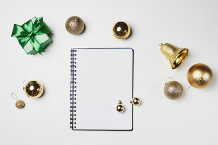 an open notebook with christmas decorations around it on a white table top view from above, copy space for textの写真素材