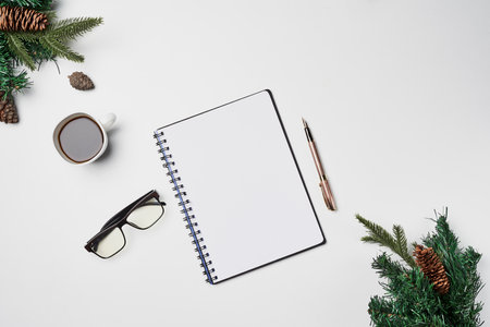 an open notebook, glasses and pine branches on a white background with copy - up text in the top right cornerの写真素材