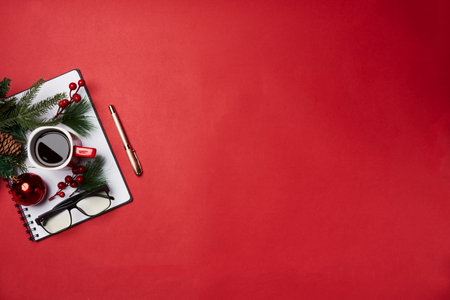 a cup of coffee and christmas decorations on a red background with copy - space for your own text or messageの写真素材