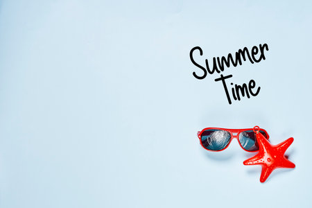 sunglasses and an airplane with the word summer time written in black ink on a white background, top view from aboveの写真素材