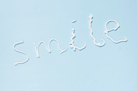the word smile written in white paint on a blue background, with an airplane flying overhead above it and belowの写真素材