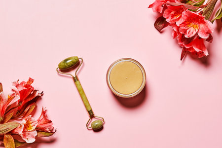 flowers and a spoon on a pink background with text overlay that reads, how to use natural skin care productsの写真素材